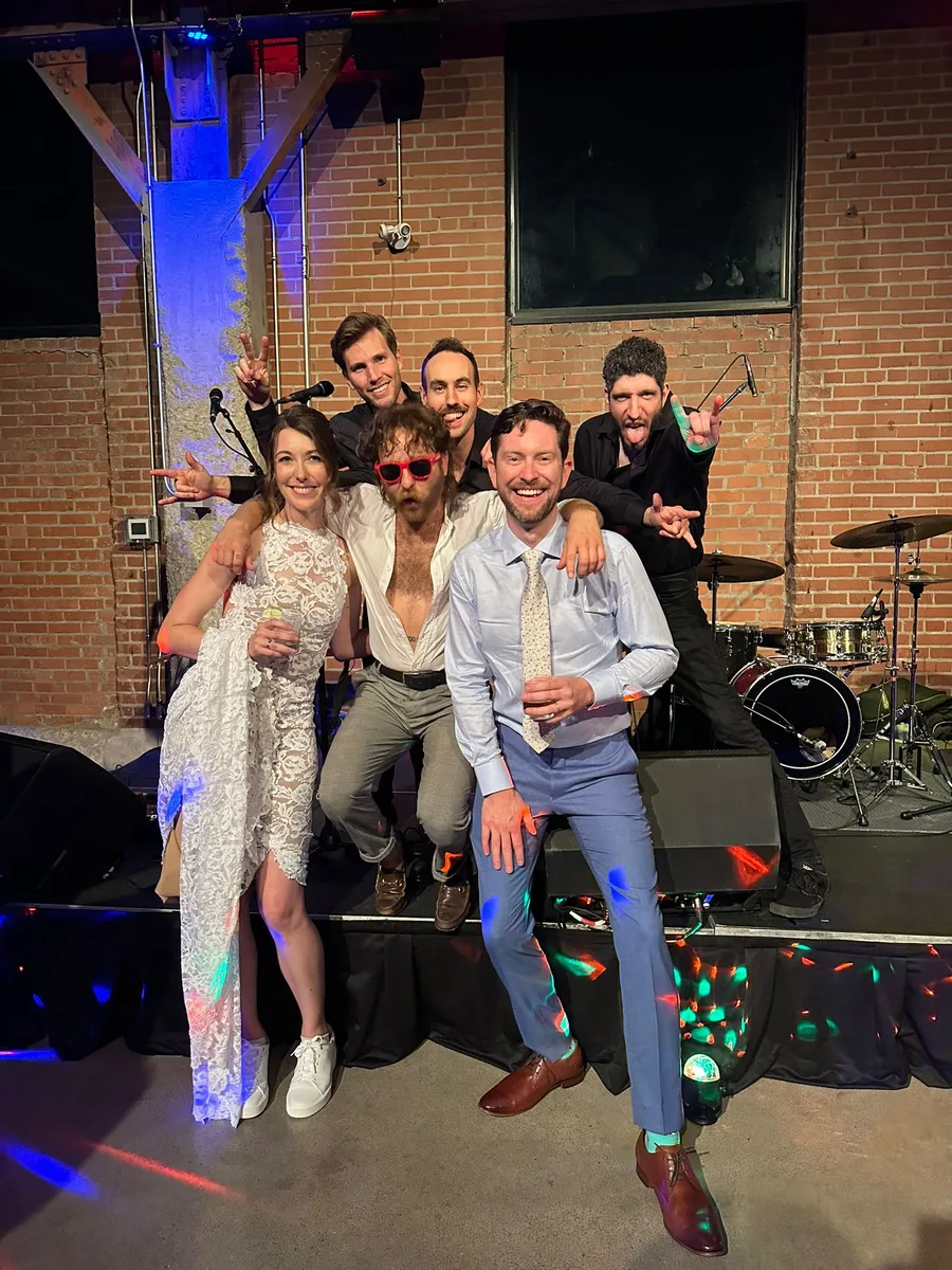 Andrew and Jess on stage at their wedding with Cory Hotline